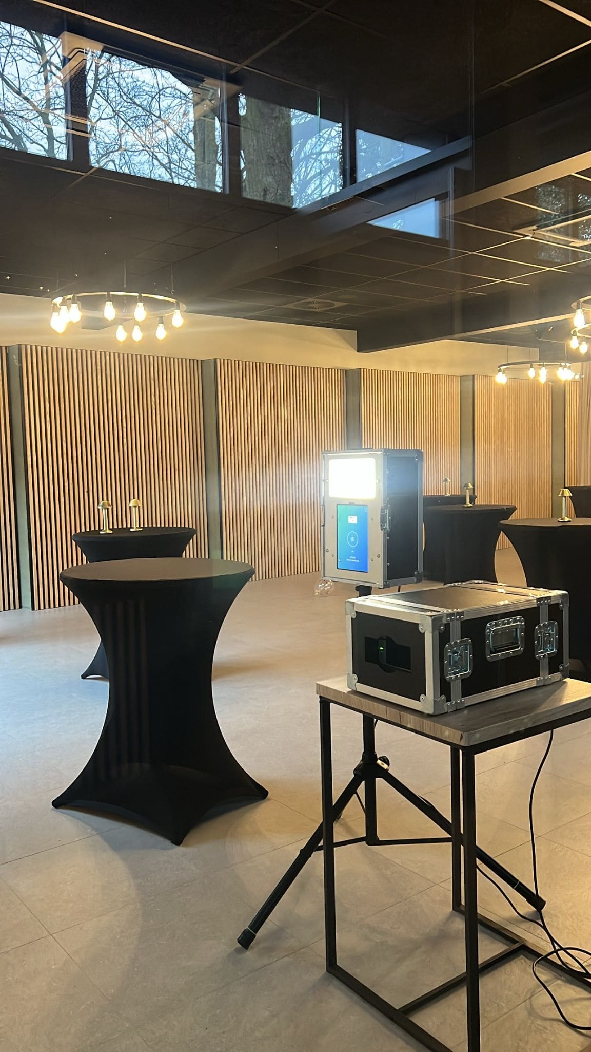 Photobooth installé dans un espace évènementiel moderne aux murs en claire-voie bois